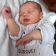 Victoire a rejoint le concours — aidez-le/la à gagner de superbes lots ! baby, newborn, sleeping, onesie, infant, closeup, soft_lighting, blanket, cozy, peaceful, cute, face, skin, hand, arm, clothing, indoors, portrait, child, resting