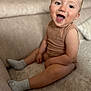 Gabin a rejoint le concours — aidez-le/la à gagner de superbes lots ! beige, child, clothing, couch, cozy, expression, face, furniture, happy, home, indoor, legs, person, plush, sitting, skin, smiling, socks, toddler, top