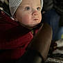 Reggie joined the competition — help win amazing prizes! baby, child, face, hat, knit_cap, jacket, red_clothing, portrait, closeup, indoors, soft_light, expression, young_child, winter_clothing, cozy, person, human, cute, warm, looking_up