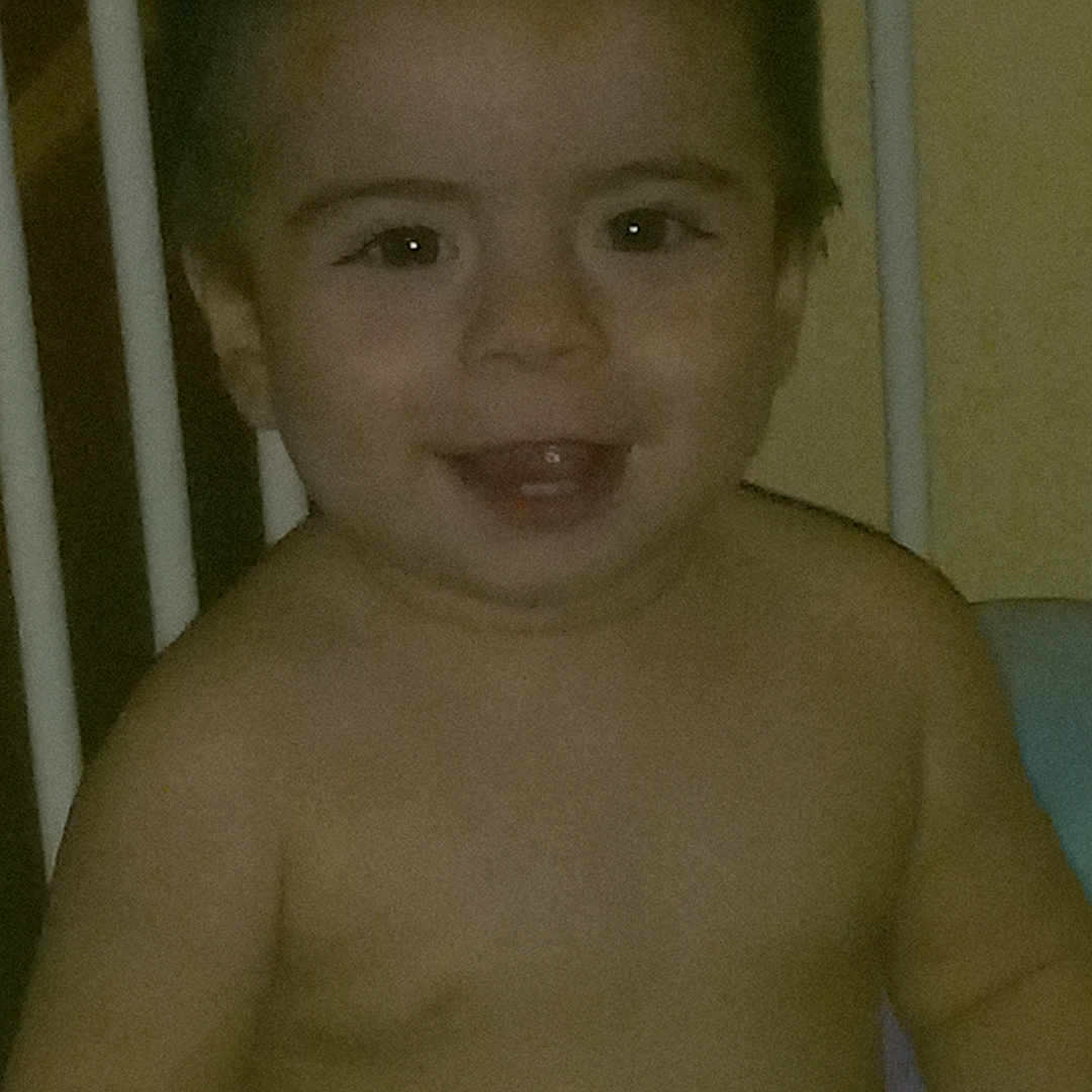 Mathayus is registered to the contest to win money with this photo: baby, bed, bodypart, crib, diaper, face, finger, furniture, hand, happy, head, infantbed, laughing, mouth, person, photography, portrait, sitting, smile, standing