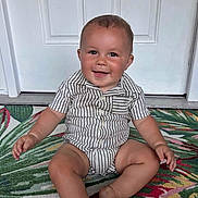 Braxton joined the competition — help win amazing prizes! baby, child, smiling, sitting, striped_clothing, romper, door, rug, colorful, indoor, happy, portrait, infant, cute, one_person, skin, face, hand, foot, young_child