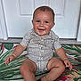 baby, child, smiling, sitting, striped_clothing, romper, door, rug, colorful, indoor, happy, portrait, infant, cute, one_person, skin, face, hand, foot, young_child