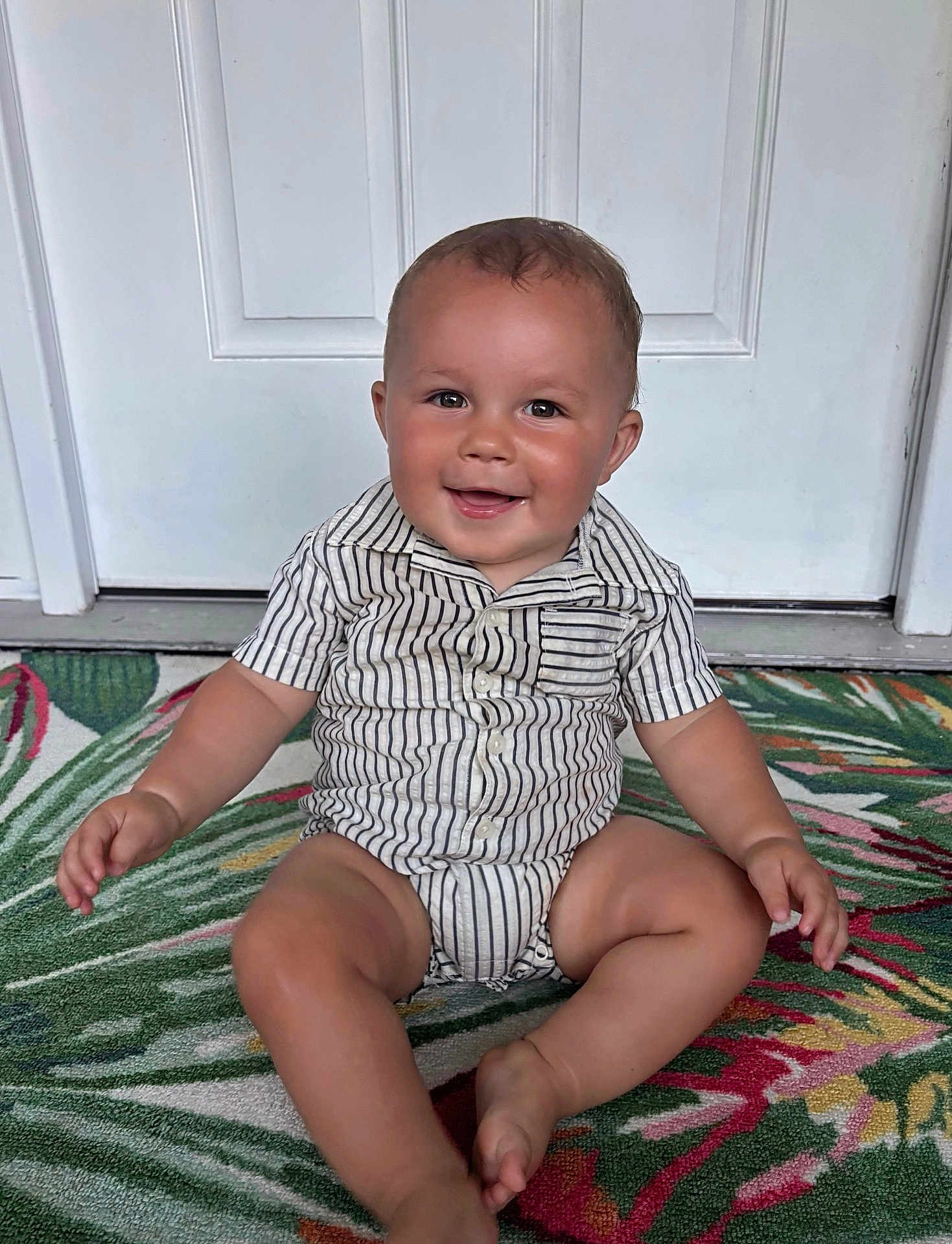 Braxton joined the competition — help win amazing prizes! baby, child, smiling, sitting, striped_clothing, romper, door, rug, colorful, indoor, happy, portrait, infant, cute, one_person, skin, face, hand, foot, young_child