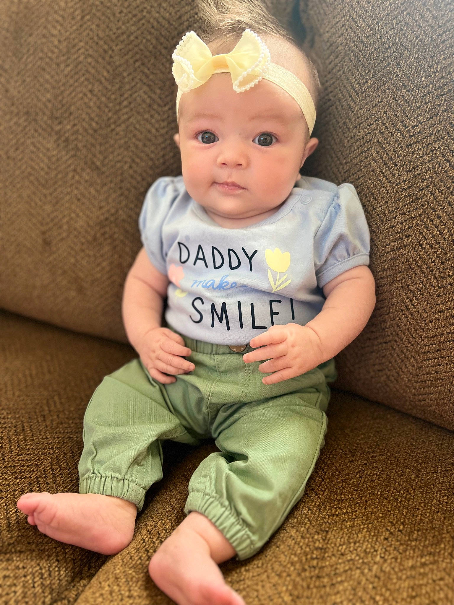 April is registered to the contest to win money with this photo: baby, baby_toddler_clothing, barefoot, cheek, child, comfort, costume_hat, eye, fashion_accessory, foot, happy, head, headband, human_leg, knee, person, sitting, skin, sleeve, t_shirt