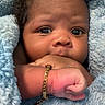 baby, infant, face, hand, bracelet, blanket, blue_blanket, curly_hair, closeup, skin, cute, newborn, wrapped, soft_texture, cozy, child, portrait, expression, fist, jewelry