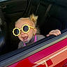 toddler, child, sunglasses, yellow, car, car_door, window, red, black_interior, happy, smiling, hair, earrings, hand, seat, leisure, summer, playful, portrait, candid