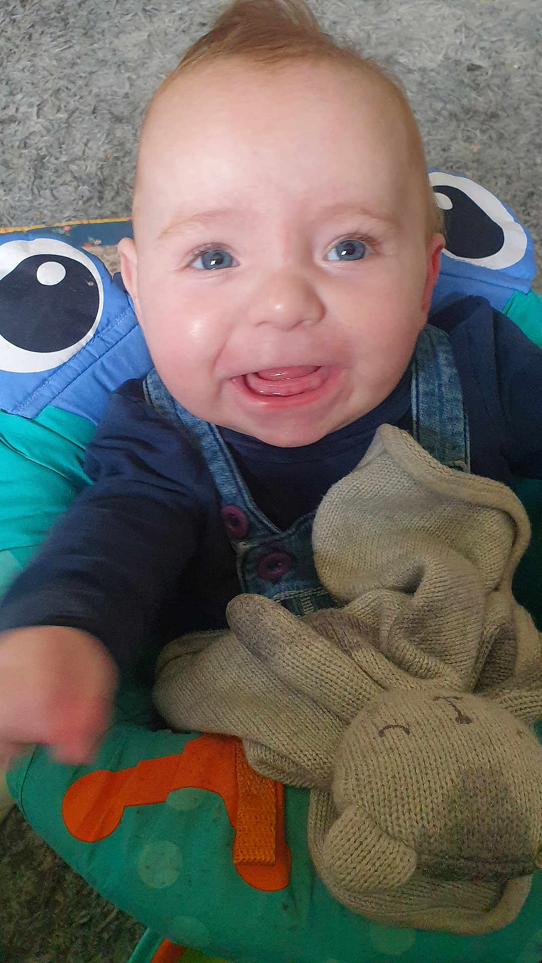 Lennie-Bluu is registered to the contest to win money with this photo: baby, child, smiling, blue_eyes, knitted_toy, bunny, baby_seat, colorful, carpet, clothing, denim, happy, indoor, cute, infant, toy, portrait, reaching, playful, toddler