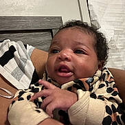 Seven is registered to the contest to win money with this photo: baby, infant, child, leopard_print, clothing, hand, face, eyes, indoor, striped_shirt, person, expression, curious, headboard, window, blinds, skin, hair, portrait, cozy