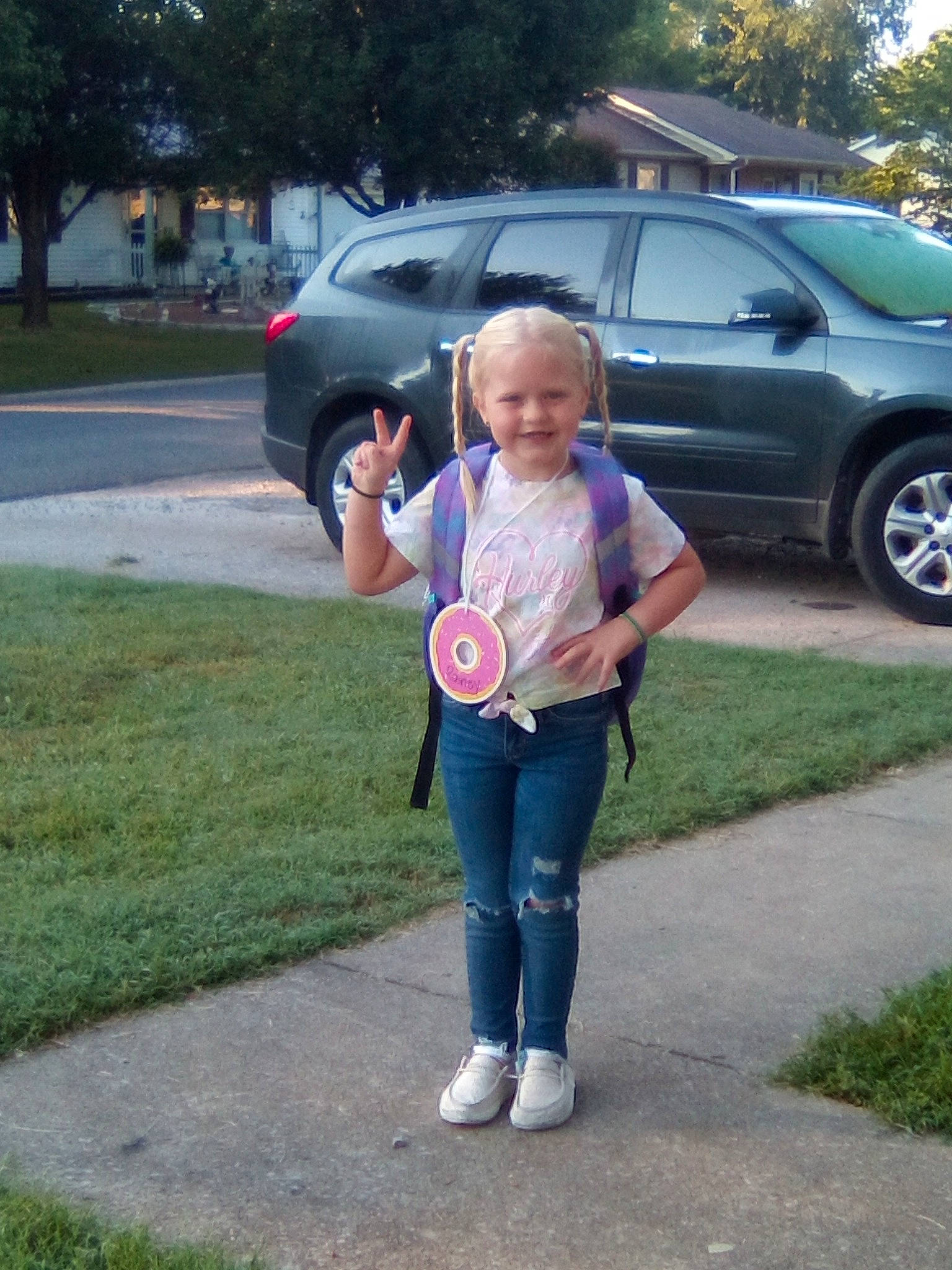 Rainey is registered to the contest to win money with this photo: asphalt, automotive_exterior, automotive_tire, bumper, car, grass, jeans, joy, land_vehicle, leisure, motor_vehicle, parking, person, plant, recreation, smile, tire, toy, tree, vehicle