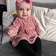 Jana participe au concours pour gagner de l'argent avec cette photo : baby, child, pink_dress, headband, bow, couch, pillow, black_tights, smile, happy, indoor, portrait, sitting, cute, infant, cozy, childrens_clothing, home, furniture, person