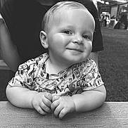 Sonny Lee is registered to the contest to win money with this photo: baby, child, smile, face, hands, table, wood, outdoor, grass, person, clothing, portrait, black_and_white, happy, cute, sitting, young_child, short_hair, toddler, casual