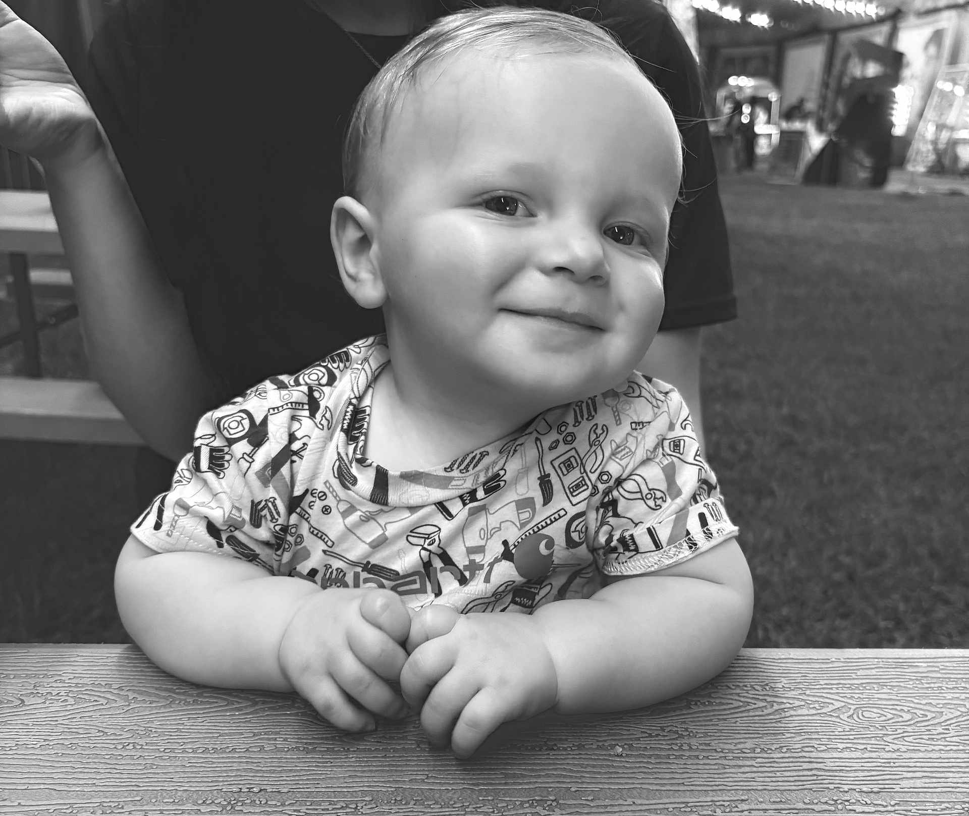 Sonny Lee is registered to the contest to win money with this photo: baby, child, smile, face, hands, table, wood, outdoor, grass, person, clothing, portrait, black_and_white, happy, cute, sitting, young_child, short_hair, toddler, casual