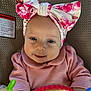 baby, infant, headband, bow, pink_clothing, smile, face, toy, colorful, seat, baby_toys, portrait, cute, child, young, indoor, closeup, happy, soft_lighting, infant_girl