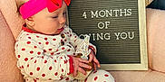 Rowyn is registered to the contest to win money with this photo: baby, infant, child, polka_dot, pajamas, headband, pink, cupcake, candle, letter_board, chair, plush, comfortable, indoor, decor, sign, celebration, cute, sitting, portrait