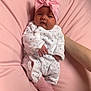 baby, infant, newborn, headband, pink, pillow, onesie, socks, hand, arm, bedding, blanket, portrait, cute, sleepy, soft_texture, cozy, indoors, nursery, person