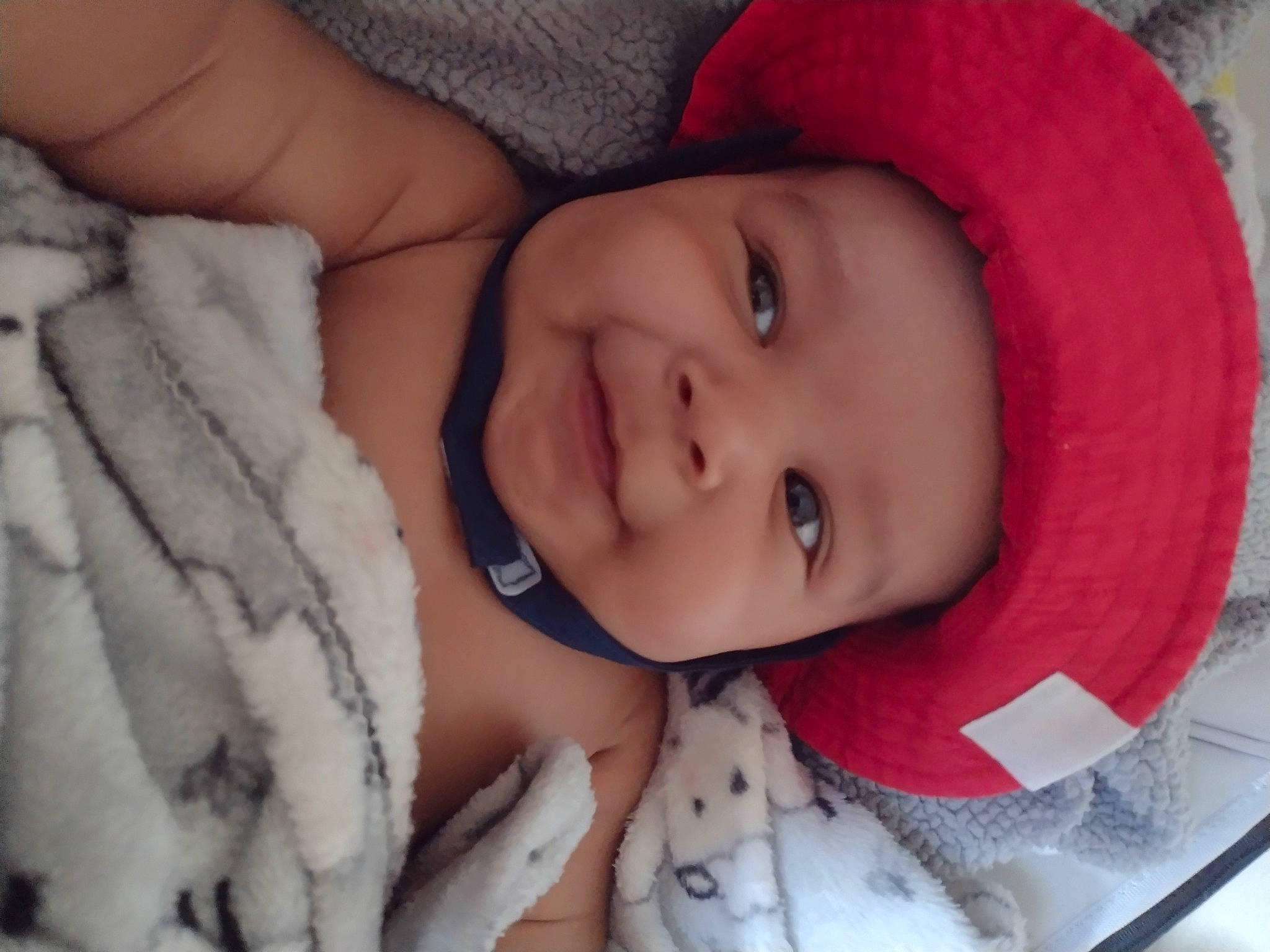 Teo is registered to the contest to win money with this photo: baby, cheek, chin, comfort, eye, eyebrow, eyelash, face, head, headwear, human, iris, lip, mammal, mouth, nose, person, pink, skin, smile