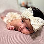 Jordan is registered to the contest to win money with this photo: baby, infant, headband, bow, cute, lying_down, blanket, soft_texture, close_up, portrait, indoor, face, skin, child, adorable, curious, young, head, expression, resting