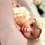 Jordan is registered to the contest to win money with this photo: baby, infant, face, headband, blanket, pink, texture, closeup, skin, expression, tongue, cute, lying_down, indoors, soft_light, portrait, child, young, person, head