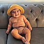 baby, child, hat, straw_hat, striped_shorts, couch, sofa, gray_furniture, smile, cute, chubby, indoors, relaxed, portrait, person, skin, bare_chest, footwear_absent, seated, happy