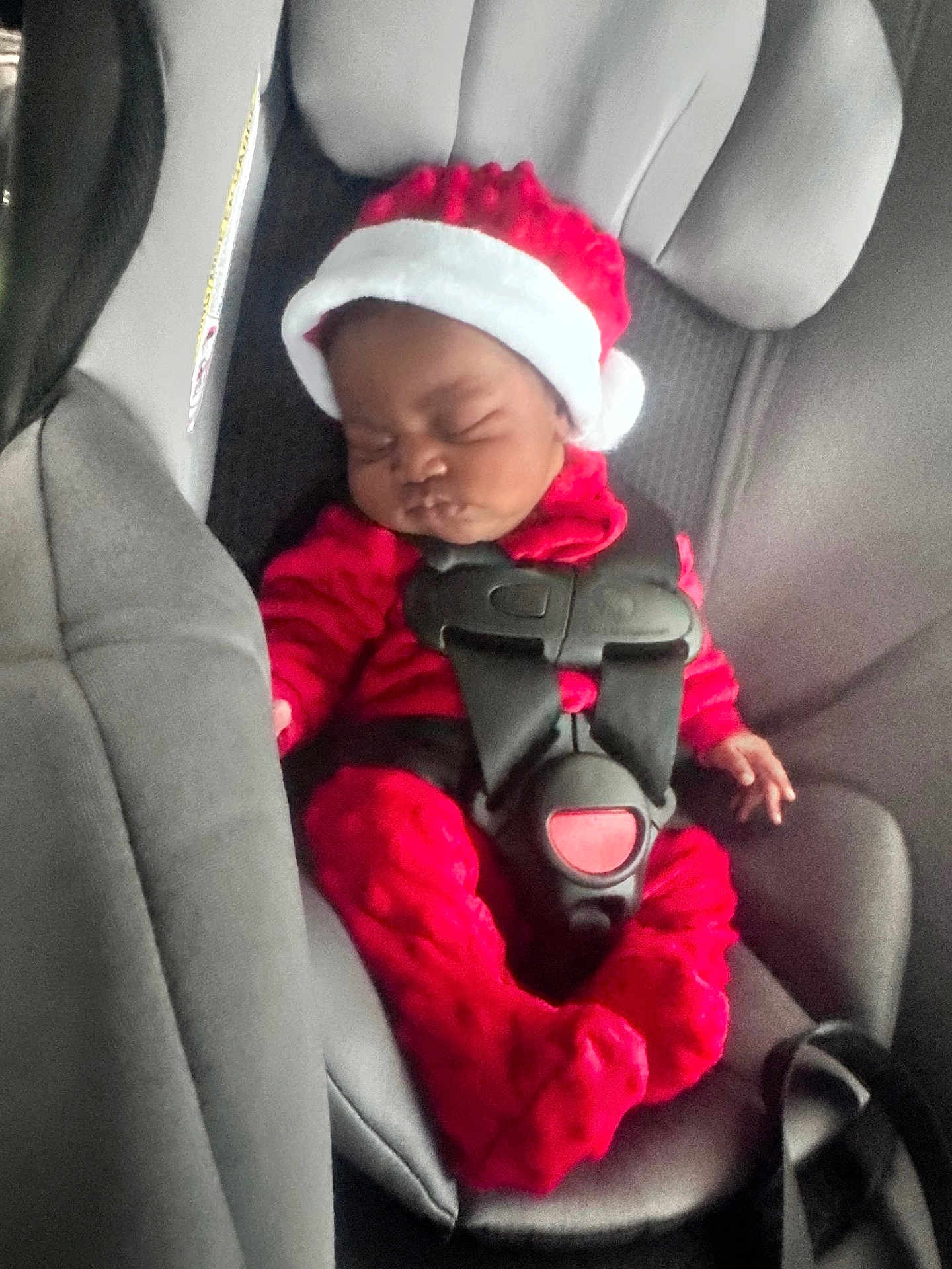 Paris joined the competition — help win amazing prizes! baby, infant, car_seat, red_clothing, santa_hat, sleeping, child, seatbelt, holiday, cute, fuzzy, indoors, person, car_interior, christmas, festive, young_child, baby_clothes, seat, safety