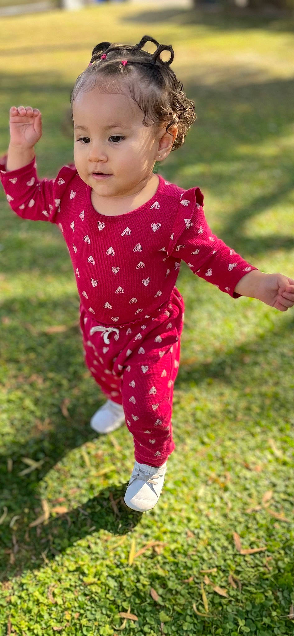 Reina is registered to the contest to win money with this photo: baby, baby_toddler_clothing, child, face, fun, gesture, grass, grassland, happy, magenta, pajamas, pattern, people_in_nature, person, pink, plant, play, sleeve, t_shirt, toddler