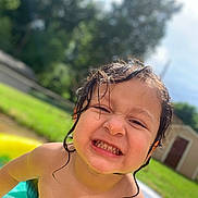Melek is registered to the contest to win money with this photo: child, toddler, wet_hair, smile, outdoor, pool, water, summer, happy, skin, face, person, grass, sunlight, background, backyard, expression, play, nature, daytime