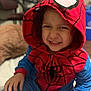 child, kid, spiderman, onesie, costume, hood, red, blue, smile, playful, indoor, portrait, face, hand, candid, cute, baby, expression, fun, person