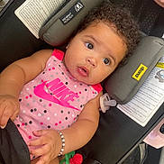 Kaliyah is registered to the contest to win money with this photo: baby, infant, car_seat, pink_clothing, nike, polka_dots, bracelet, pacifier, curly_hair, teether, cute, child, portrait, indoor, seatbelt, expression, adorable, person, closeup, comfort