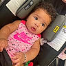 baby, infant, car_seat, pink_clothing, nike, polka_dots, bracelet, pacifier, curly_hair, teether, cute, child, portrait, indoor, seatbelt, expression, adorable, person, closeup, comfort