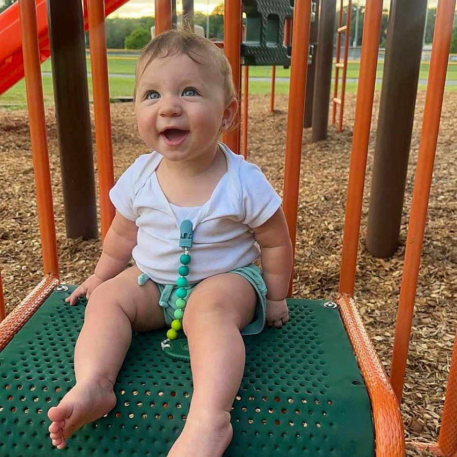 Paisley is registered to the contest to win money with this photo: accessories, baby, diaper, face, furniture, grass, happy, head, jewelry, nature, outdoorplayarea, outdoors, park, person, photography, plant, playarea, portrait, sitting, summer