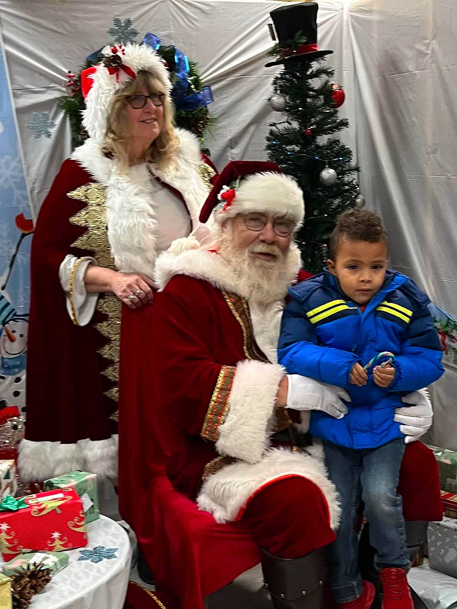 Demari is registered to the contest to win money with this photo: beard, christmas, christmas_decoration, christmas_ornament, christmas_tree, event, happy, hat, headwear, holiday, human_body, joy, lap, organ, person, plant, red, santa_claus, smile, tradition