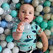 Asher joined the competition — help win amazing prizes! baby, child, face, ball_pit, plastic_balls, blue, white, aqua, clear_ball, shirt, fish_pattern, hand, portrait, indoor, playtime, cute, infant, young_child, colorful, reaching
