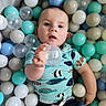baby, child, face, ball_pit, plastic_balls, blue, white, aqua, clear_ball, shirt, fish_pattern, hand, portrait, indoor, playtime, cute, infant, young_child, colorful, reaching
