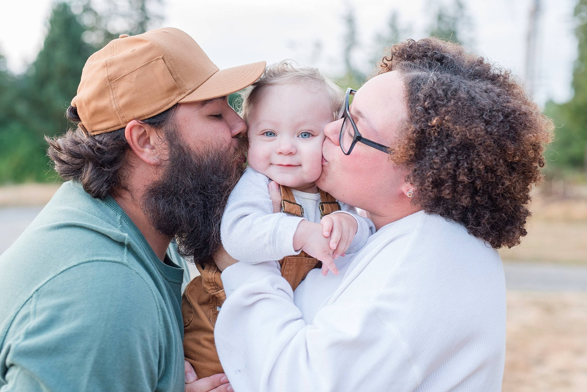 Makoa is registered to the contest to win money with this photo: baby, baseball_cap, beard, cap, event, eyewear, face, facial_expression, fun, gesture, grass, hairstyle, happy, headwear, interaction, kiss, leisure, people_in_nature, person, skin