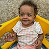 Harmony joined the competition — help win amazing prizes! toddler, child, smile, curly_hair, yellow_seat, pink_clothing, checkered_pattern, outdoor, playground, happy, person, baby, sitting, cute, casual_wear, infant, small_child, portrait, daylight, young