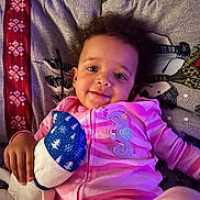 Harmony is registered to the contest to win money with this photo: toddler, child, pink_onesie, stuffed_toy, blanket, smiling, indoors, cozy, relaxed, cute, portrait, baby, couch, home, soft_lighting, casual, happy, young_child, person, comfortable