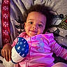 baby, blanket, casual, child, comfortable, couch, cozy, cute, happy, home, indoors, person, pink_onesie, portrait, relaxed, smiling, soft_lighting, stuffed_toy, toddler, young_child