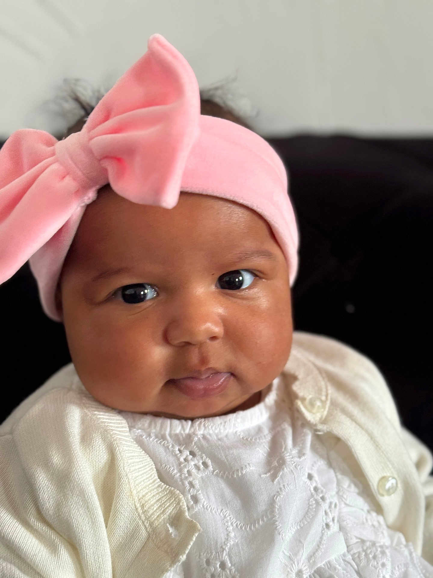 Tyla a rejoint le concours — aidez-le/la à gagner de superbes lots ! baby, infant, face, headband, pink_bow, clothing, white_outfit, close_up, portrait, cute, child, young, chubby_cheeks, eyes, looking, soft_light, indoors, person, apparel, headwear