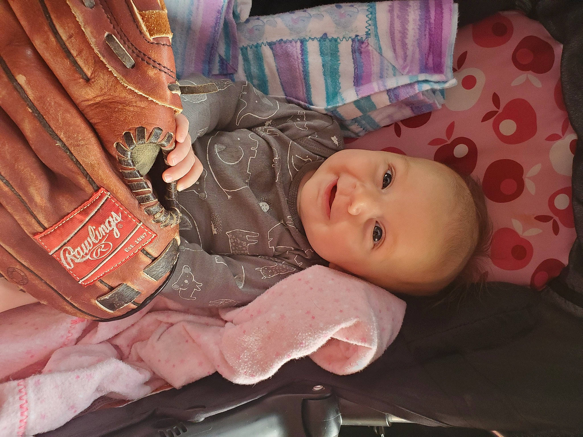 Olive is registered to the contest to win money with this photo: baby, baby_carriage, baby_products, baby_toddler_clothing, car_seat, cheek, child, doll, hat, mouth, nail, pattern, peach, person, room, sitting, skin, smile, toddler, toy