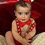 baby, child, red_crown, red_bow_tie, red_suspender, rose, balloons, fluffy_blanket, heart_shapes, indoor, portrait, cute, smiling, celebration, festive, holiday, valentines_day, soft_texture, infant, happy