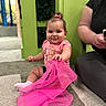Aelfwynn is registered to the contest to win money with this photo: baby, child, pink_bow, pink_shirt, sitting, carpet, fabric, playful, smiling, indoor, person, adult, green_wall, toy, cute, happy, girl, floor, casual_clothing, holding