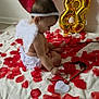 baby, infant, child, angel_wings, headband, balloon, gold_balloon, red_balloon, rose_petals, heart_shape, blanket, sitting, profile, diaper, cute, celebration, party_decoration, wooden_bow, earring, indoor