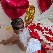 Mirana is registered to the contest to win money with this photo: baby, infant, diaper, angel_wings, heart_balloon, gold_balloon, red_petals, blanket, crawling, headband, back_of_head, skin, party_decor, indoor, white_wall, soft_texture, celebration, ribbon, floor, photography