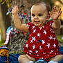 Savannah is registered to the contest to win money with this photo: toddler, child, red_dress, stars, outdoor, grass, tree_trunk, blue_blanket, stuffed_animal, patriotic, toy, celebration, happy, smiling, arms_up, cute, sunlight, nature, decorations, portrait