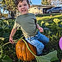 Luca is registered to the contest to win money with this photo: blue_jeans, boy, car, casual_clothing, child, daytime, fall, garden, grass, green_shirt, happy, house, leaf, nature, outdoor, plants, pumpkin, smiling, sunlight, vine