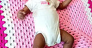 Leimani is registered to the contest to win money with this photo: baby, infant, child, onesie, sock, blanket, crochet, pink, white, smile, cute, lying_down, portrait, indoor, soft_texture, happy, young_child, toddler, footwear, person