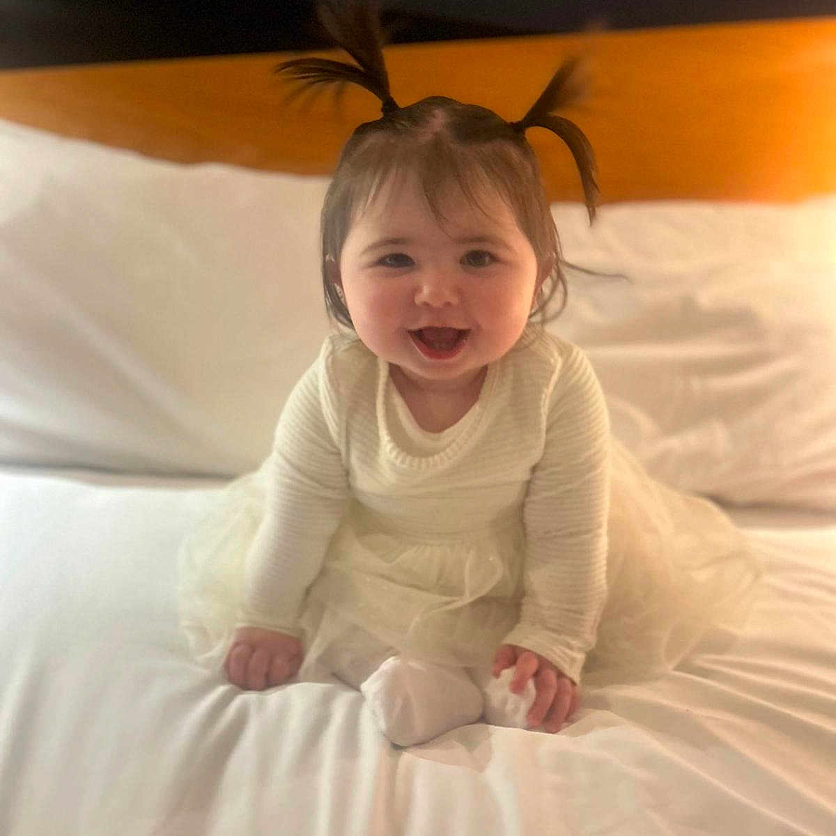 Olivia is registered to the contest to win money with this photo: baby, babylaughing, bed, bedroom, clothing, crawling, cushion, dress, face, furniture, happy, head, homedecor, indoors, pants, person, photography, portrait, room, sitting