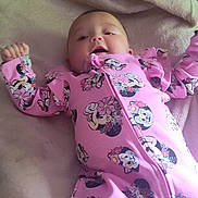 Lilian joined the competition — help win amazing prizes! baby, infant, pink_clothing, onesie, minnie_mouse, blanket, bed, pillow, cushion, sleepwear, person, child, cute, lying_down, indoor, soft_texture, patterned_clothing, head, face, smiling