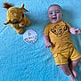 baby, infant, smiling, yellow_clothing, plush_toy, simba, blue_blanket, milestone_card, lying_down, cute, happy, child, soft_texture, portrait, six_months, toddler, toy, clothing, baby_boy, indoor