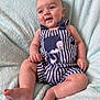 baby, infant, smiling, striped_clothing, romper, bear_design, sitting, soft_blanket, light_blue, cute, chubby_cheeks, happy, indoors, child, one_person, portrait, skin, foot, hand, young